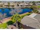 Aerial view of community lake, desert landscaping, nearby houses, and grassy lawns at 42432 W North Star Dr, Maricopa, AZ 85138