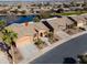 Aerial view showing desert landscaping, a concrete driveway, and nearby houses surrounding a lake at 42432 W North Star Dr, Maricopa, AZ 85138