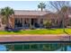 Beautiful waterfront backyard with covered patio and mature landscaping along the water's edge at 42432 W North Star Dr, Maricopa, AZ 85138