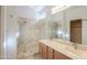 Bright bathroom featuring a double vanity, large mirror, and glass-enclosed shower with tile surround at 42432 W North Star Dr, Maricopa, AZ 85138