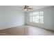 Bedroom with tile flooring, a ceiling fan, neutral paint, and backyard views at 42432 W North Star Dr, Maricopa, AZ 85138