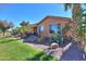 Home exterior featuring a landscaped backyard with desert plants, river rock, and a well-manicured lawn at 42432 W North Star Dr, Maricopa, AZ 85138