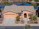 Aerial front exterior showcasing desert landscaping, concrete driveway, shutters, and tile roof at 42432 W North Star Dr, Maricopa, AZ 85138