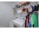 Bright laundry room with appliances and shelving for organized storage at 42432 W North Star Dr, Maricopa, AZ 85138