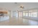 Open-concept living room with tile floors, ceiling fan, and view to the pond at 42432 W North Star Dr, Maricopa, AZ 85138