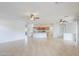 Spacious living room with tile flooring, ceiling fans, and a kitchen view at 42432 W North Star Dr, Maricopa, AZ 85138