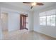 Open-concept living room featuring tile flooring, a ceiling fan, and views of the front door at 42432 W North Star Dr, Maricopa, AZ 85138