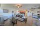 Open floor plan living room featuring tile floors, ceiling fan, sofa, and view into kitchen at 42432 W North Star Dr, Maricopa, AZ 85138