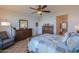 Enjoy this spacious main bedroom with a cozy sitting area, ceiling fan, and tile flooring, plus ensuite access at 42432 W North Star Dr, Maricopa, AZ 85138