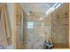 Modern shower featuring a multi-setting shower fixture surrounded by earth-tone tiled walls and glass enclosure at 42432 W North Star Dr, Maricopa, AZ 85138