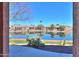 Back patio view of pond with lush greenery, trees, and neighboring homes at 42432 W North Star Dr, Maricopa, AZ 85138