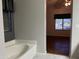 Primary bathroom view featuring a bathtub, window and doorway into an empty bedroom at 4511 S 181St Ave, Goodyear, AZ 85338