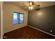 An empty bedroom with a ceiling fan and wood-look floors basks in natural light from the window at 4511 S 181St Ave, Goodyear, AZ 85338