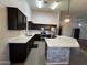 Modern kitchen with stainless steel appliances, quartz countertops, dark wood cabinetry, and luxury lighting at 4511 S 181St Ave, Goodyear, AZ 85338