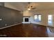 Open living room with wood floors, a gray accent wall, and a modern stone fireplace at 4511 S 181St Ave, Goodyear, AZ 85338