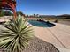 An inviting backyard pool with a rock waterfall feature is surrounded by desert plants at 4511 S 181St Ave, Goodyear, AZ 85338