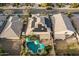 Aerial view highlighting a house with solar panels, a pool with patio umbrellas, and a well-manicured backyard at 4521 W Maggie Dr, San Tan Valley, AZ 85144