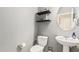 Cozy powder room with a pedestal sink, floating shelves, and neutral wall color at 4521 W Maggie Dr, San Tan Valley, AZ 85144