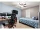 Well-lit bedroom with ceiling fan, desk with computer monitors, and full-sized bed at 4521 W Maggie Dr, San Tan Valley, AZ 85144