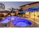 Backyard at dusk featuring a pool and spa with blue umbrellas, perfect for a relaxing evening at 4521 W Maggie Dr, San Tan Valley, AZ 85144