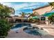 Sparkling backyard pool and spa complemented by mature palm trees, desert landscaping, and resort-style umbrellas at 4521 W Maggie Dr, San Tan Valley, AZ 85144