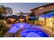 Inviting backyard pool and spa with beautiful blue lighting, lush landscaping, and resort-style umbrellas at 4521 W Maggie Dr, San Tan Valley, AZ 85144