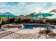 Inviting backyard pool and spa area with lush landscaping and shade umbrellas for relaxing or entertaining at 4521 W Maggie Dr, San Tan Valley, AZ 85144