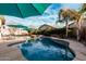 Entertain outdoors in this backyard featuring a pool with spa, desert landscaping, and resort-style patio umbrellas at 4521 W Maggie Dr, San Tan Valley, AZ 85144