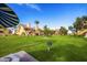 Exterior view of well-maintained townhomes with green grass, palm trees, and blue sky at 4901 S Calle Los Cerros Dr # 264, Tempe, AZ 85282