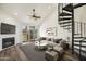 Staged living room with spiral staircase, vaulted ceilings, wood-look floors, fireplace, and patio doors at 4901 S Calle Los Cerros Dr # 264, Tempe, AZ 85282