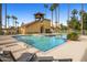 Relaxing community pool with lounge chairs, palm trees, and clear blue water at 4901 S Calle Los Cerros Dr # 264, Tempe, AZ 85282