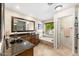 Well-lit bathroom with a large soaking tub, dark stone countertops, and vanity area at 5024 E Le Marche Ave, Scottsdale, AZ 85254