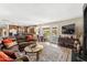 Open-concept living room and kitchen featuring a leather sofa, tv, and access to the backyard at 5024 E Le Marche Ave, Scottsdale, AZ 85254