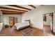 Bedroom with beamed ceiling, terra cotta flooring, a large window, and comfortable rocking chair at 5567 E Mcdonald Dr, Paradise Valley, AZ 85253