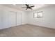 Bright bedroom with sleek floors, ceiling fan, window, and spacious closet with sliding doors at 5731 W Morten Ave, Glendale, AZ 85301