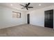 Bright bedroom featuring sleek floors, ceiling fan, and a contrasting dark doors for a touch of elegance at 5731 W Morten Ave, Glendale, AZ 85301