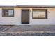 Close-up view of the front door and entry featuring rock landscaping and updated fixtures at 5731 W Morten Ave, Glendale, AZ 85301