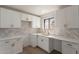 Bright kitchen featuring white cabinets, counters, and herringbone backsplash at 5731 W Morten Ave, Glendale, AZ 85301