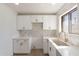 Bright kitchen featuring white cabinets, counters, and herringbone backsplash at 5731 W Morten Ave, Glendale, AZ 85301