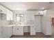 Bright kitchen featuring white cabinets, counters, and herringbone backsplash at 5731 W Morten Ave, Glendale, AZ 85301