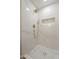 Elegant walk-in shower with decorative tile, sleek fixtures, and a built-in shelf for added convenience at 5731 W Morten Ave, Glendale, AZ 85301