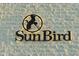 Close-up of an illuminated 'Sun Bird' community sign against a textured brick wall at 6177 S Sawgrass Dr, Chandler, AZ 85249