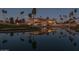 Stunning exterior view of the resort building, featuring palm trees and a water reflection at dusk at 6177 S Sawgrass Dr, Chandler, AZ 85249