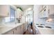 Bright kitchen featuring white appliances and cabinets, patterned wallpaper, and wood floors at 624 Hawk Eye Dr, Apache Junction, AZ 85119