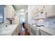 Bright kitchen featuring white appliances and cabinets, patterned wallpaper, and wood floors at 624 Hawk Eye Dr, Apache Junction, AZ 85119