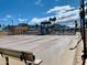 Community shuffleboard court surrounded by benches and beautiful palm trees under the bright blue sky at 624 Hawk Eye Dr, Apache Junction, AZ 85119