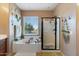 Bright bathroom with a glass-enclosed shower and a relaxing soaking tub under a large window at 6795 S Sapphire Way, Chandler, AZ 85249