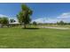 Community common area with grassy field, covered pavilion, and volleyball court under a clear blue sky at 6795 S Sapphire Way, Chandler, AZ 85249