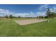 Outdoor sand volleyball court surrounded by green grass and mature trees, perfect for community fun at 6795 S Sapphire Way, Chandler, AZ 85249