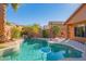 Inviting backyard pool area with lush landscaping, palm trees, and a serene waterfall feature at 7138 W Buckskin Trl, Peoria, AZ 85383